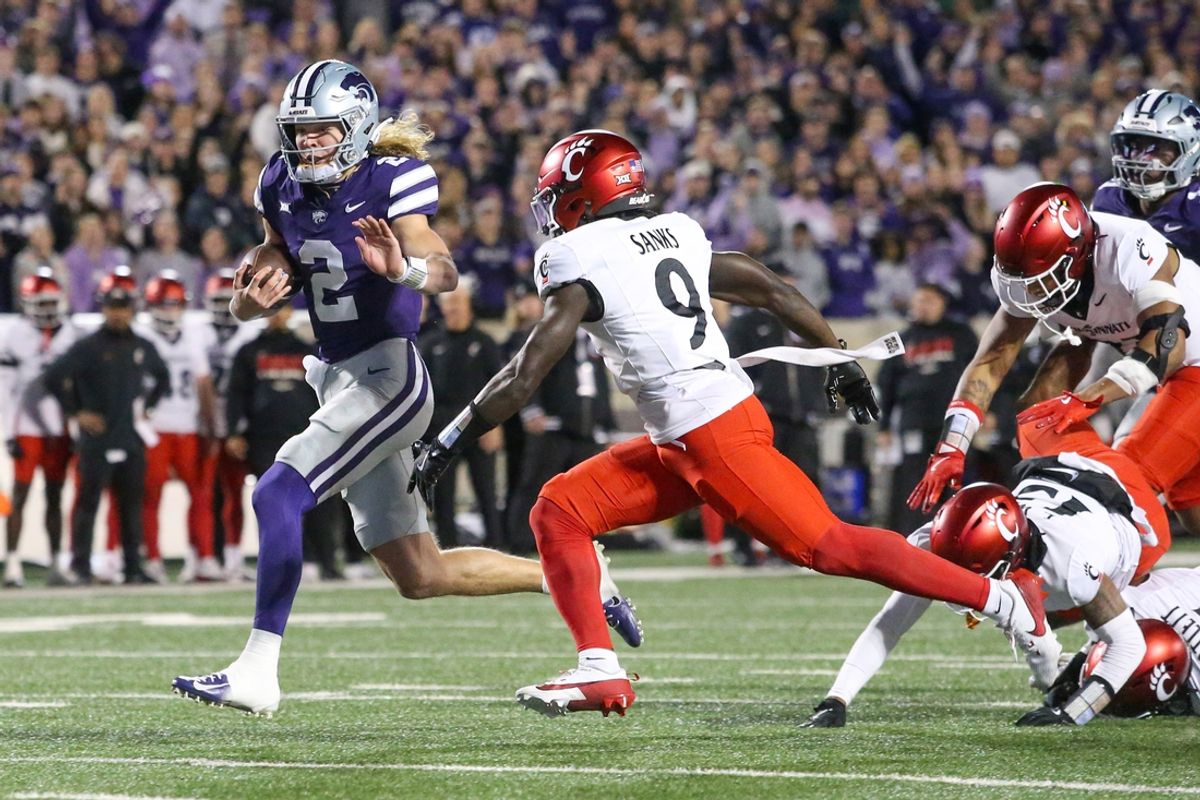 Nov 23, 2024; Manhattan, Kansas, USA; Kansas State Wildcats quarterback Avery Johnson (2) runs by Cincinnati Bearcats linebacker Jiquan Sanks (9) for a touchdown in the first quarter at Bill Snyder Family Football Stadium. Mandatory Credit: Scott Sewell-Imagn Images
