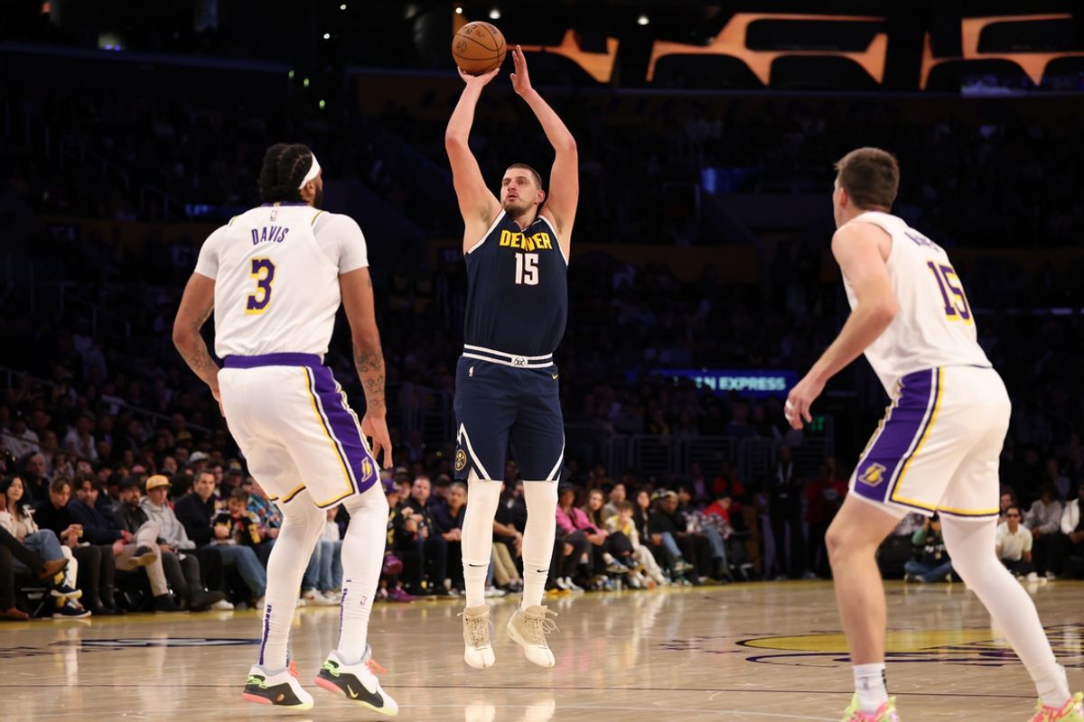 Nov 23, 2024; Los Angeles, California, USA;  Denver Nuggets center Nikola Jokic (15) shoots a three-point shot against Los Angeles Lakers forward Anthony Davis (3) during the first quarter at Crypto.com Arena. Mandatory Credit: Kiyoshi Mio-Imagn Images
