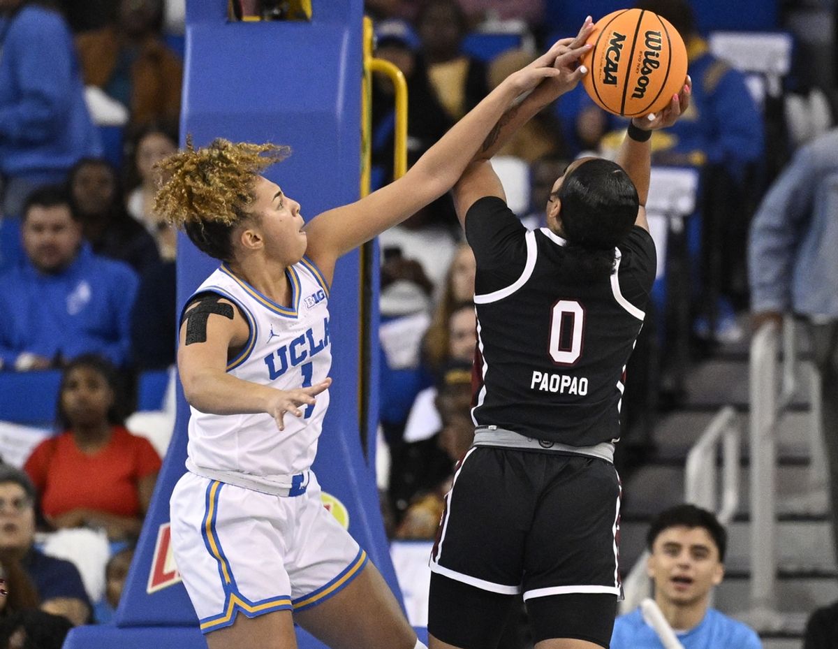 Nov 24, 2024; Los Angeles, California, USA; UCLA Bruins guard Kiki Rice (1) blocks a shot by South Carolina Gamecocks guard Te-Hina Paopao (0) during the first quarter at Pauley Pavilion presented by Wescom. Mandatory Credit: Robert Hanashiro-Imagn Images