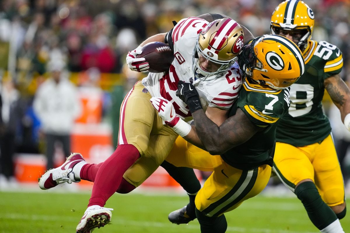 Nov 24, 2024; Green Bay, Wisconsin, USA;  San Francisco 49ers running back Christian McCaffrey (23) is tackled by Green Bay Packers linebacker Quay Walker (7) during the second quarter at Lambeau Field. Mandatory Credit: Jeff Hanisch-Imagn Images