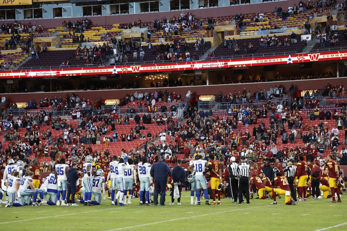 Nov 24, 2024; Landover, Maryland, USA; Dallas Cowboys and Washington Commanders players stand and kneel on the field during an injury timeout for Commanders running back Austin Ekeler (not pictured) during the fourth quarter at Northwest Stadium. Mandatory Credit: Geoff Burke-Imagn Images