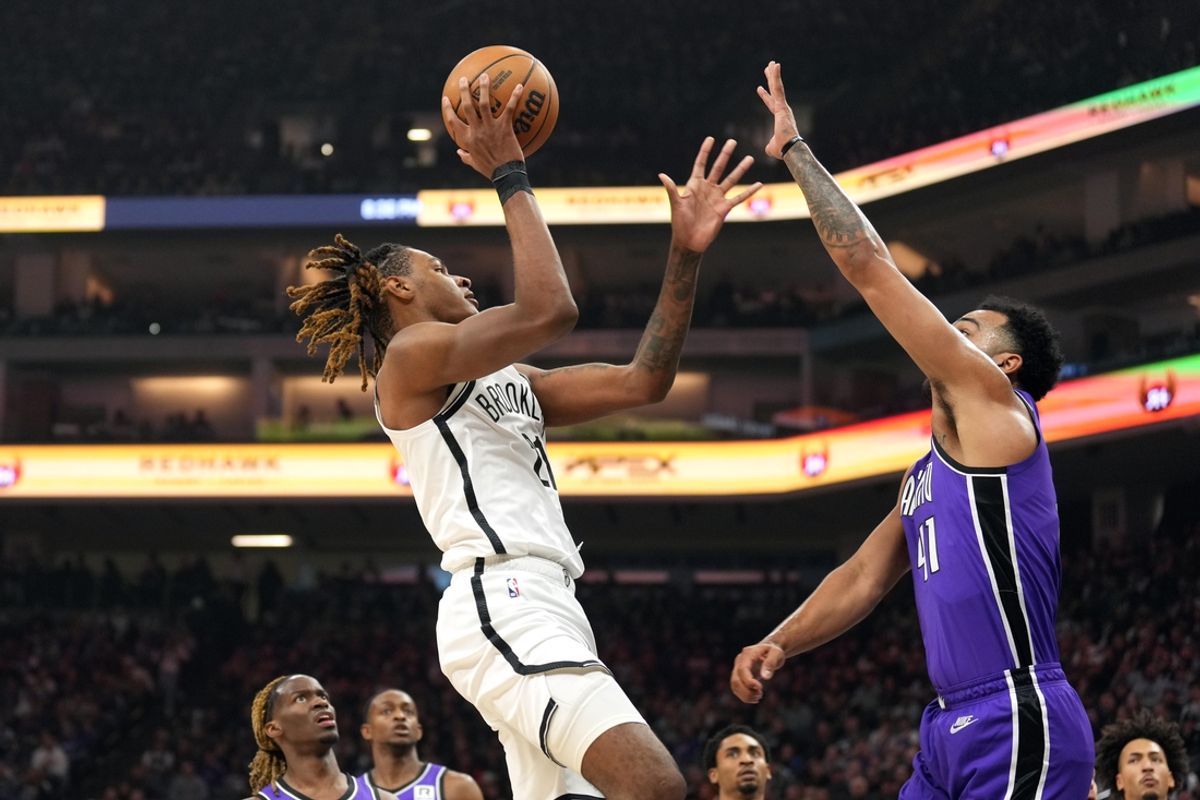 Nov 24, 2024; Sacramento, California, USA; Brooklyn Nets forward Noah Clowney (left) shoots against Sacramento Kings forward Trey Lyles (right) during the first quarter at Golden 1 Center. Mandatory Credit: Darren Yamashita-Imagn Images