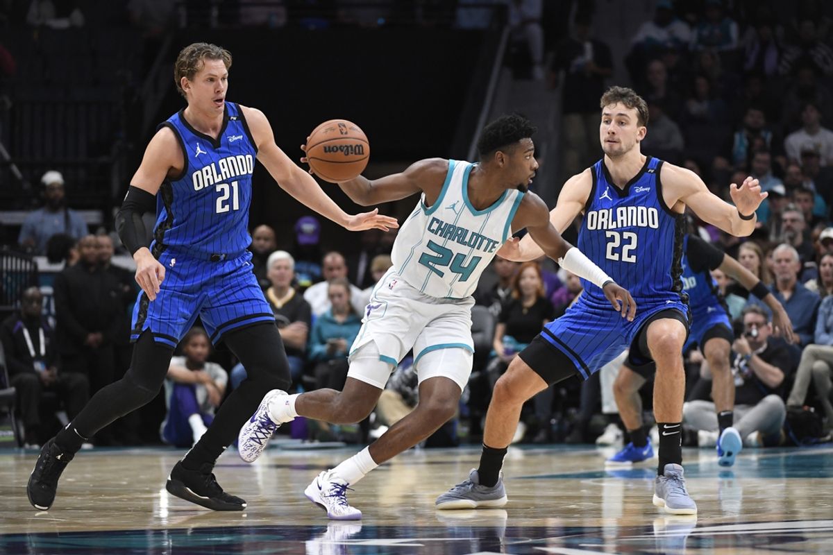 Nov 25, 2024; Charlotte, North Carolina, USA;  Charlotte Hornets forward Brandon Miller (24) drives past Orlando Magic center Moritz Wagner (21) and forward Franz Wagner (22) during the first half at the Spectrum Center. Mandatory Credit: Sam Sharpe-Imagn Images