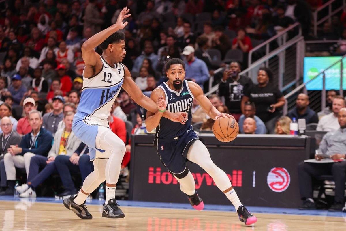 Nov 25, 2024; Atlanta, Georgia, USA; Dallas Mavericks guard Spencer Dinwiddie (26) drives on Atlanta Hawks forward De'Andre Hunter (12) in the second quarter at State Farm Arena. Mandatory Credit: Brett Davis-Imagn Images