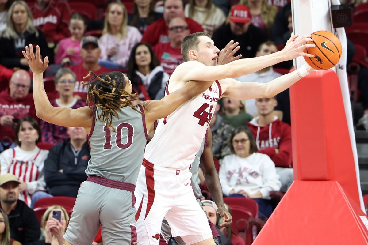 Nov 25, 2024; Fayetteville, Arkansas, USA; Arkansas Razorbacks forward Zvonimir Ivisic (44) reaches for a rebound as Maryland Eastern Shore Hawks guard Jose Cuello (10) defends at Bud Walton Arena. Mandatory Credit: Nelson Chenault-Imagn Images