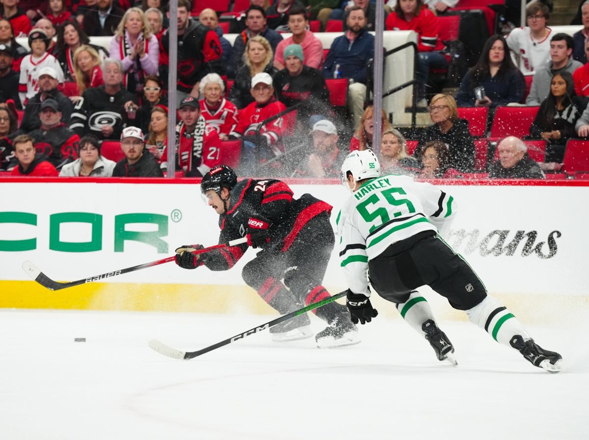Nov 25, 2024; Raleigh, North Carolina, USA;  Carolina Hurricanes center Seth Jarvis (24) skates with the puck against Dallas Stars defenseman Thomas Harley (55) during the third period at Lenovo Center. Mandatory Credit: James Guillory-Imagn Images