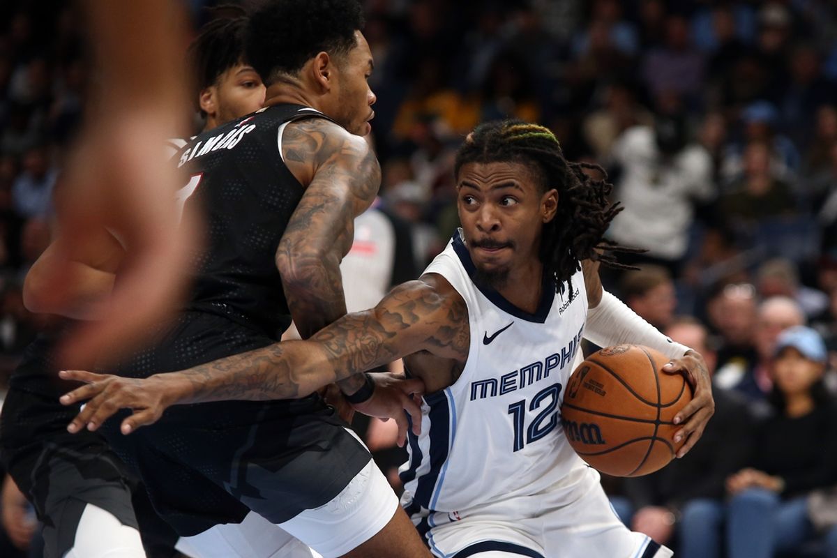 Nov 25, 2024; Memphis, Tennessee, USA; Memphis Grizzlies guard Ja Morant (12) drives to the basket as Portland Trail Blazers guard Anfernee Simons (1) defends during the first half at FedExForum. Mandatory Credit: Petre Thomas-Imagn Images