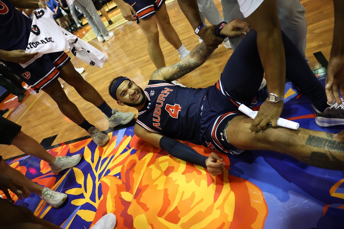 Nov 25, 2024; Lahaina, Hawaii, USA;  After scoring the winning basket against the Iowa State Cyclones, Auburn Tigers forward Johni Broome (4) lays on the court after getting a cramp at the end of an NCAA college basketball game at Lahaina Civic Center. Auburn defeated Iowa State 83-81. Mandatory Credit: Marco Garcia-Imagn Images