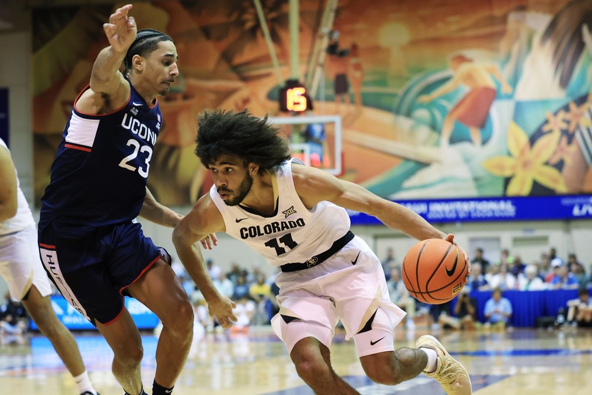 Nov 26, 2024; Lahaina, Hawaii, USA;  Colorado Buffaloes guard Javon Ruffin (11) drives past Connecticut Huskies forward Jayden Ross (23) during the first half of an NCAA college basketball game at Lahaina Civic Center. Mandatory Credit: Marco Garcia-Imagn Images