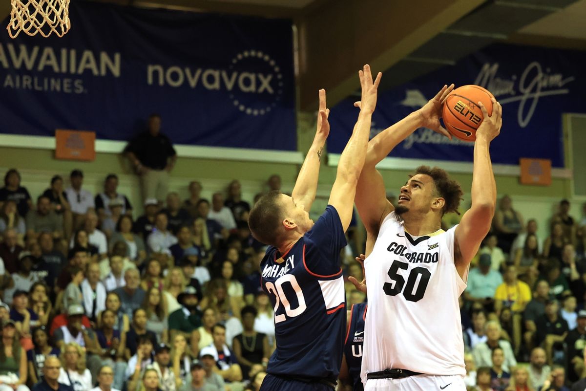 Nov 26, 2024; Lahaina, Hawaii, USA;  Colorado Buffaloes center Elijah Malone (50) goes for the net as Connecticut Huskies guard Aidan Mahaney (20) guards him during the first half of an NCAA college basketball game at Lahaina Civic Center. Mandatory Credit: Marco Garcia-Imagn Images
