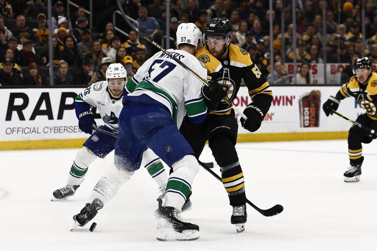 Nov 26, 2024; Boston, Massachusetts, USA; Vancouver Canucks defenseman Tyler Myers (57) tries to keep Boston Bruins right wing Justin Brazeau (55) from a loose puck during the first period at TD Garden. Mandatory Credit: Winslow Townson-Imagn Images