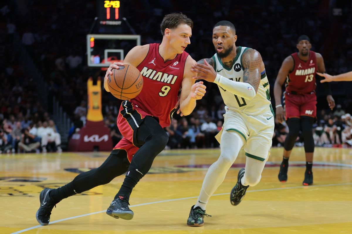 Nov 26, 2024; Miami, Florida, USA; Miami Heat guard Pelle Larsson (9) drives to the basket against Milwaukee Bucks guard Damian Lillard (0) during the second quarter at Kaseya Center. Mandatory Credit: Sam Navarro-Imagn Images