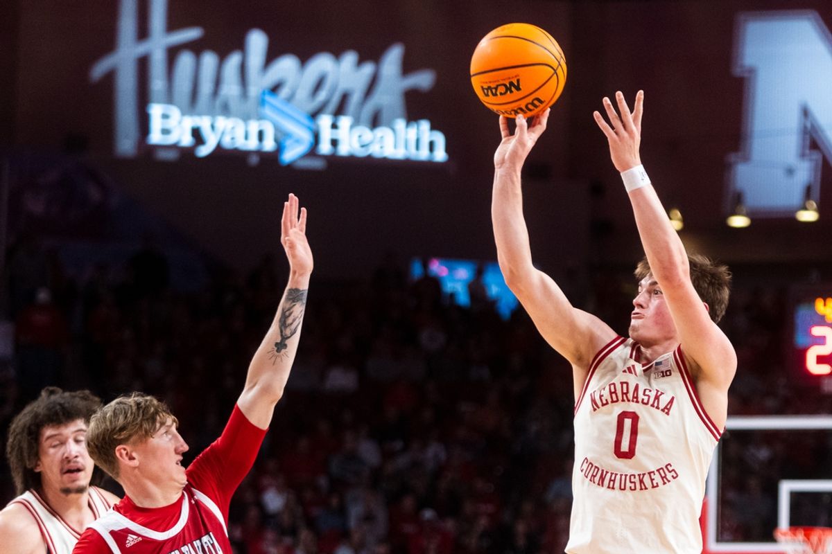 Nov 27, 2024; Lincoln, Nebraska, USA; Nebraska Cornhuskers guard Connor Essegian (0) shoots a three-point basket against South Dakota Coyotes guard Shey Eberwein (2) during the first half at Pinnacle Bank Arena. Mandatory Credit: Dylan Widger-Imagn Images