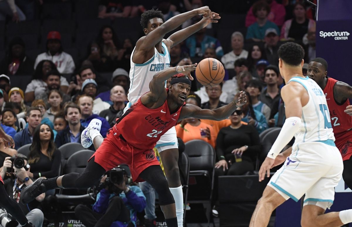 Nov 27, 2024; Charlotte, North Carolina, USA;  Miami Heat forward Jimmy Butler (22) goes after a loose ball during the first half against the Charlotte Hornets at the Spectrum Center. Mandatory Credit: Sam Sharpe-Imagn Images