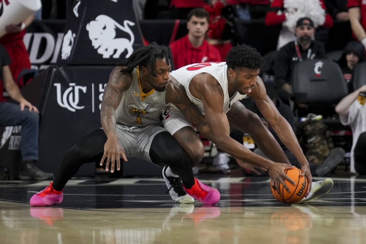 Nov 27, 2024; Cincinnati, Ohio, USA; Alabama State Hornets center Mario Andrews (4) battles for the loose ball against Cincinnati Bearcats guard Josh Reed (10) in the first half at Fifth Third Arena. Mandatory Credit: Aaron Doster-Imagn Images