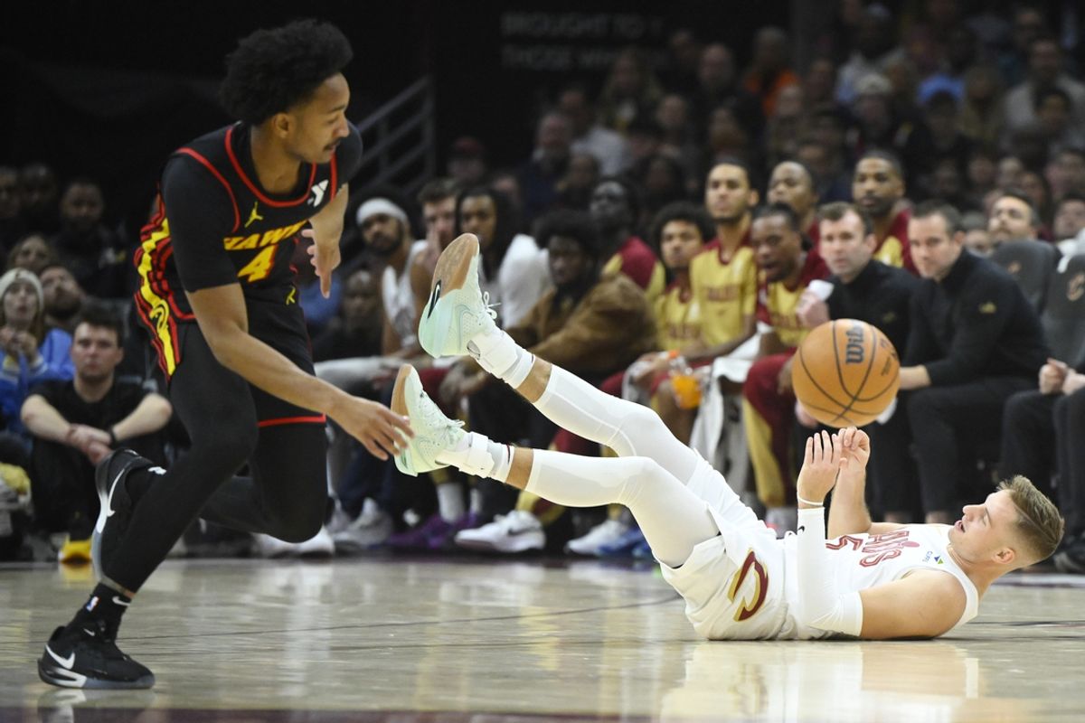 Nov 27, 2024; Cleveland, Ohio, USA; Cleveland Cavaliers guard Sam Merrill (5) falls to the court as Atlanta Hawks guard Kobe Bufkin (4) reaches for the ball in the first quarter at Rocket Mortgage FieldHouse. Mandatory Credit: David Richard-Imagn Images