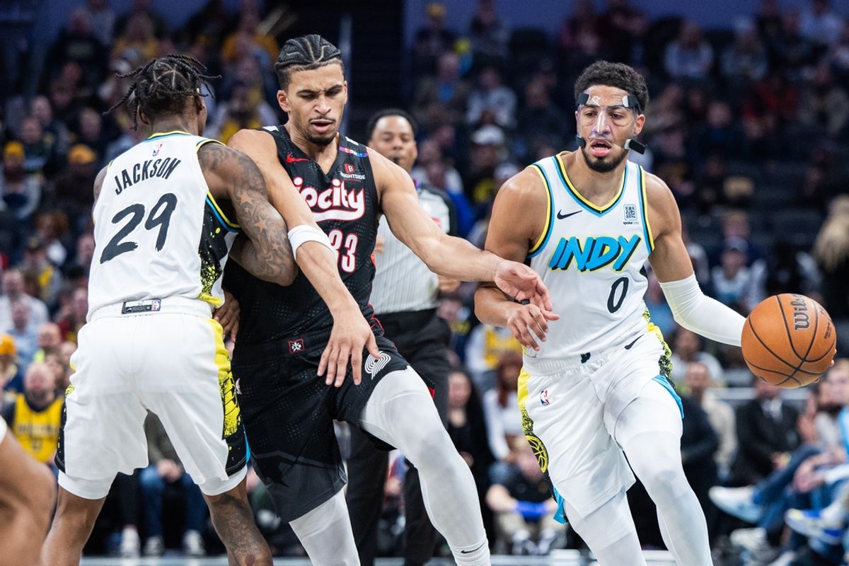 Nov 27, 2024; Indianapolis, Indiana, USA; Indiana Pacers guard Tyrese Haliburton (0) dribbles the ball while Portland Trail Blazers forward Toumani Camara (33)  defends in the first half at Gainbridge Fieldhouse. Mandatory Credit: Trevor Ruszkowski-Imagn Images