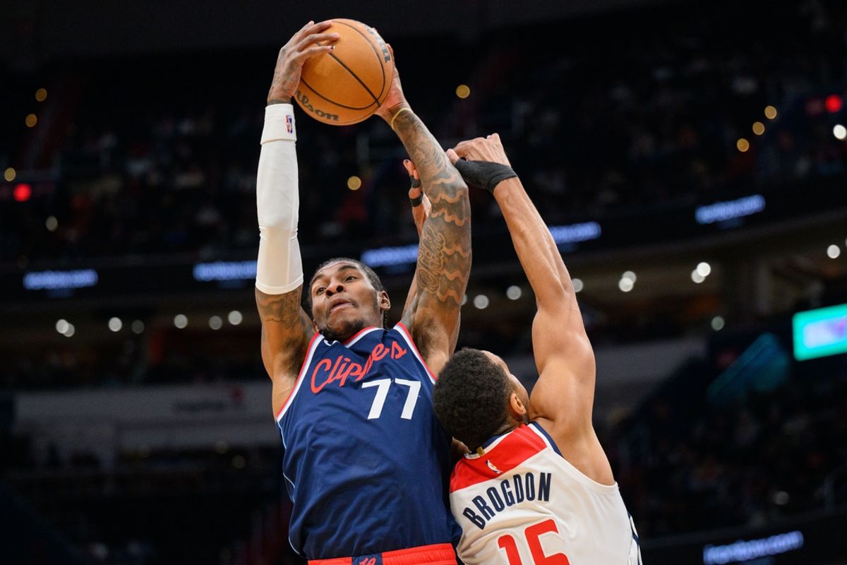 Nov 27, 2024; Washington, District of Columbia, USA; LA Clippers guard Kevin Porter Jr. (77) grabs a rebound over Washington Wizards guard Malcolm Brogdon (15) during the second quarter at Capital One Arena. Mandatory Credit: Reggie Hildred-Imagn Images