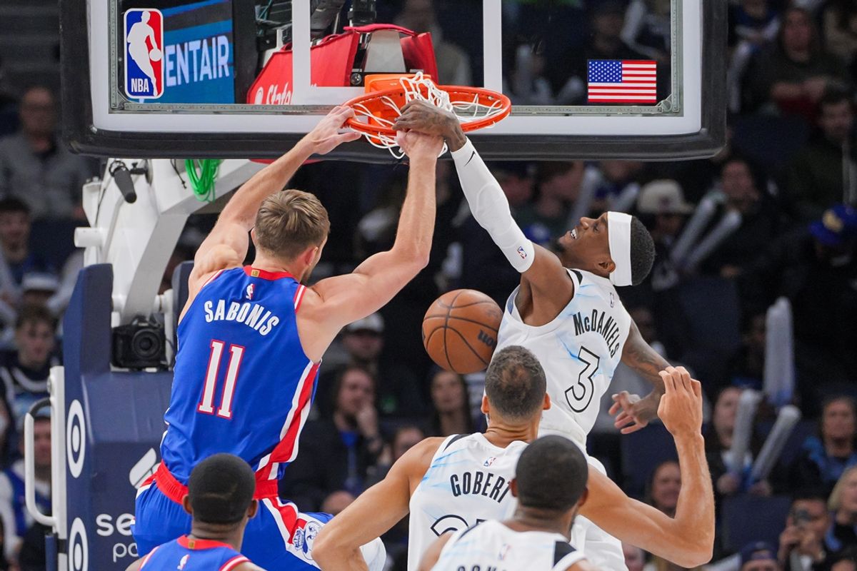 Nov 27, 2024; Minneapolis, Minnesota, USA; Sacramento Kings forward Domantas Sabonis (11) dunks against the Minnesota Timberwolves forward Jaden McDaniels (3) in the first quarter at Target Center. Mandatory Credit: Brad Rempel-Imagn Images