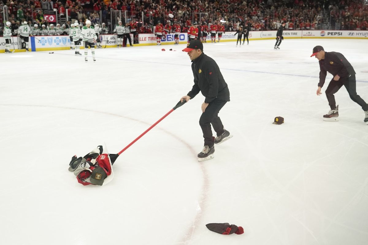 Nov 27, 2024; Chicago, Illinois, USA; The Ice Crew sweep up hats after Chicago Blackhawks left wing Taylor Hall (not pictured )  scored a hat trick against the Dallas Stars during the second period at United Center. Mandatory Credit: David Banks-Imagn Images