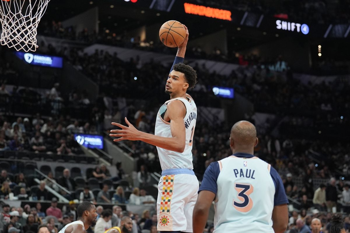 Nov 27, 2024; San Antonio, Texas, USA;  San Antonio Spurs center Victor Wembanyama (1) grabs a rebound in front of guard Chris Paul (3) in the second half against the Los Angeles Lakers at Frost Bank Center. Mandatory Credit: Daniel Dunn-Imagn Images