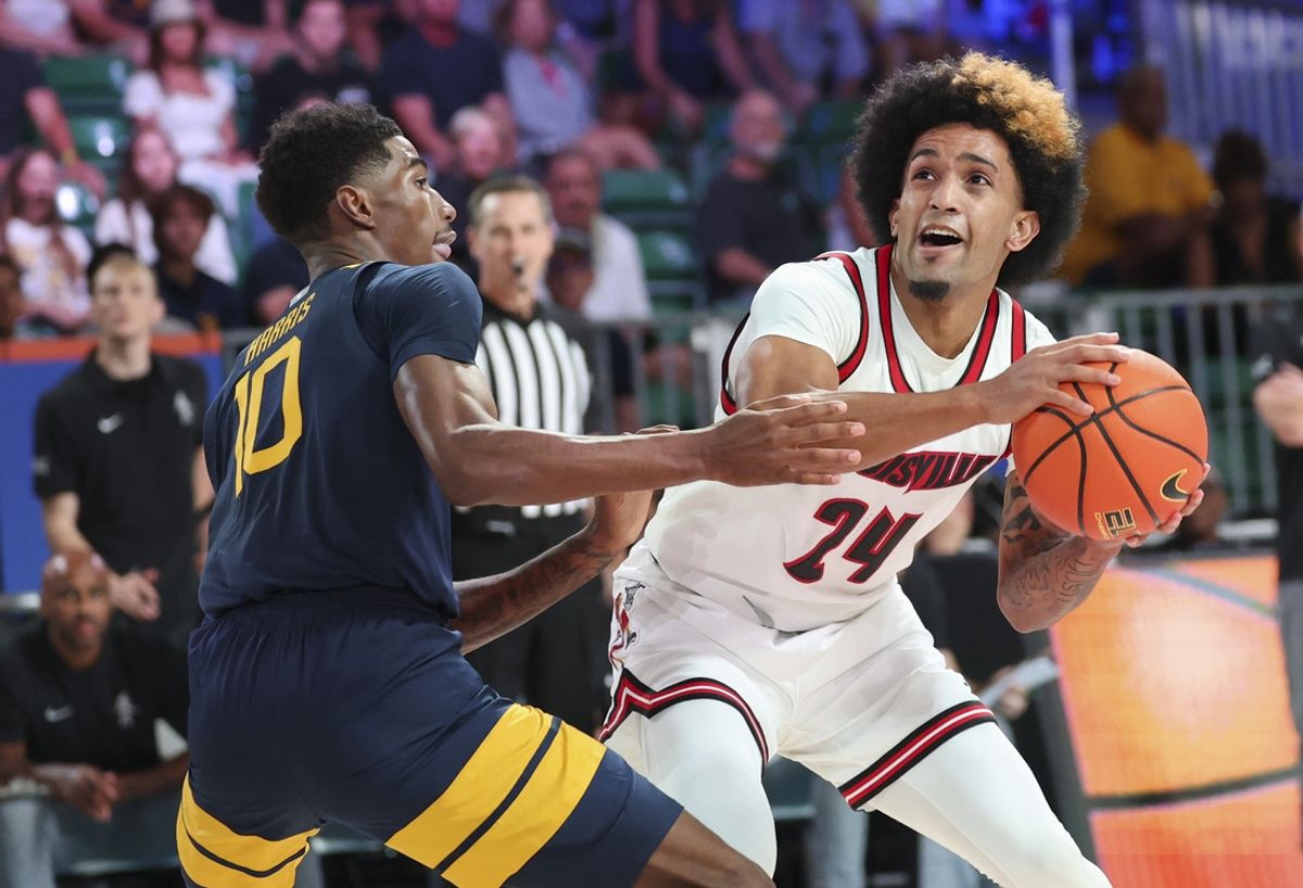 Nov 28, 2024; Paradise Island, Bahamas, BHS;  Louisville Cardinals guard Chucky Hepburn (24) looks to shoot as West Virginia Mountaineers guard Sencire Harris (10) defends during the first half at Imperial Arena at the Atlantis resort.  Mandatory Credit: Kevin Jairaj-Imagn Images