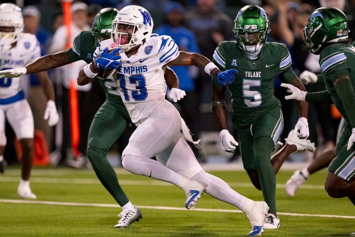 Nov 28, 2024; New Orleans, Louisiana, USA; Memphis Tigers running back Greg Desrosiers Jr. (13) breaks away from Tulane Green Wave linebacker Chris Rodgers (4) finishing off the play with a touchdown during the second quarter at Yulman Stadium. Mandatory Credit: Matthew Hinton-Imagn Images