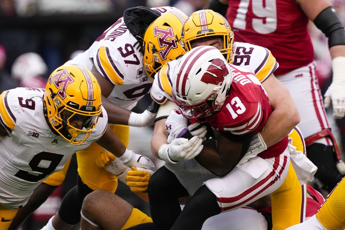 Nov 29, 2024; Madison, Wisconsin, USA;  Wisconsin Badgers running back Darrion Dupree (13) is tackled by Minnesota Golden Gophers defensive lineman Danny Striggow (92) during the second quarter at Camp Randall Stadium. Mandatory Credit: Jeff Hanisch-Imagn Images