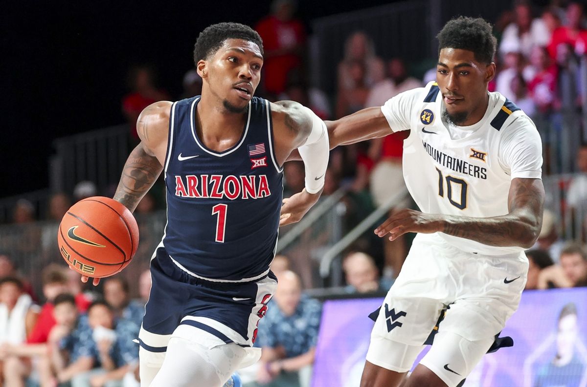 Nov 29, 2024; Paradise Island, Bahamas, BHS; Arizona Wildcats guard Caleb Love (1) drives to the basket as West Virginia Mountaineers guard Sencire Harris (10) defends  during the first half at Imperial Arena at the Atlantis resort.  Mandatory Credit: Kevin Jairaj-Imagn Images