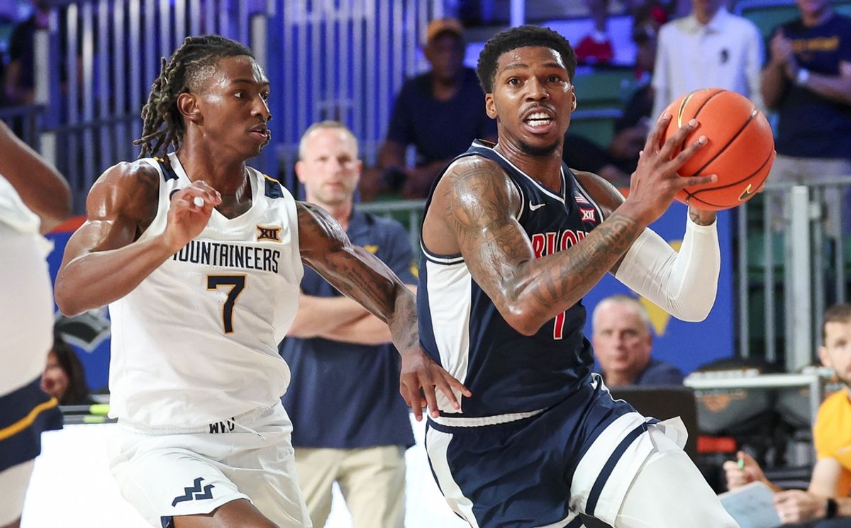 Nov 29, 2024; Paradise Island, Bahamas, BHS;  Arizona Wildcats guard Caleb Love (1) drives to the basket as West Virginia Mountaineers guard Javon Small (7) defends during the first half at Imperial Arena at the Atlantis resort.  Mandatory Credit: Kevin Jairaj-Imagn Images