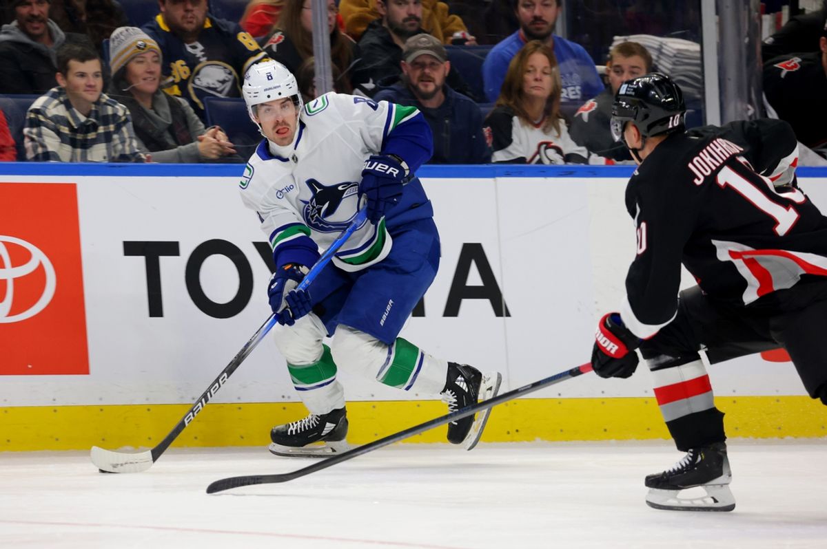 Nov 29, 2024; Buffalo, New York, USA;  Vancouver Canucks right wing Conor Garland (8) looks to make a pass as Buffalo Sabres defenseman Henri Jokiharju (10) defends during the first period at KeyBank Center. Mandatory Credit: Timothy T. Ludwig-Imagn Images