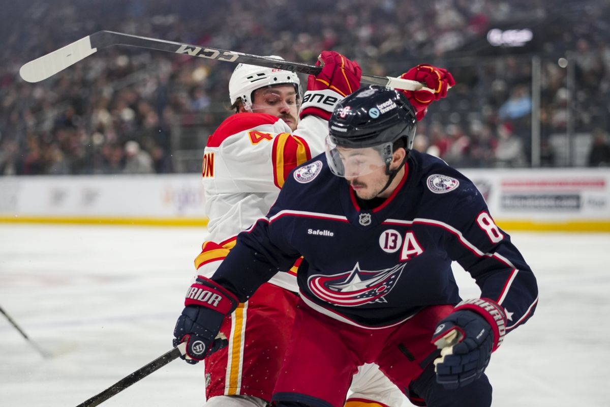 Nov 29, 2024; Columbus, Ohio, USA;  Calgary Flames defenseman Rasmus Andersson (4) skates against Columbus Blue Jackets defenseman Zach Werenski (8) in the first period at Nationwide Arena. Mandatory Credit: Aaron Doster-Imagn Images
