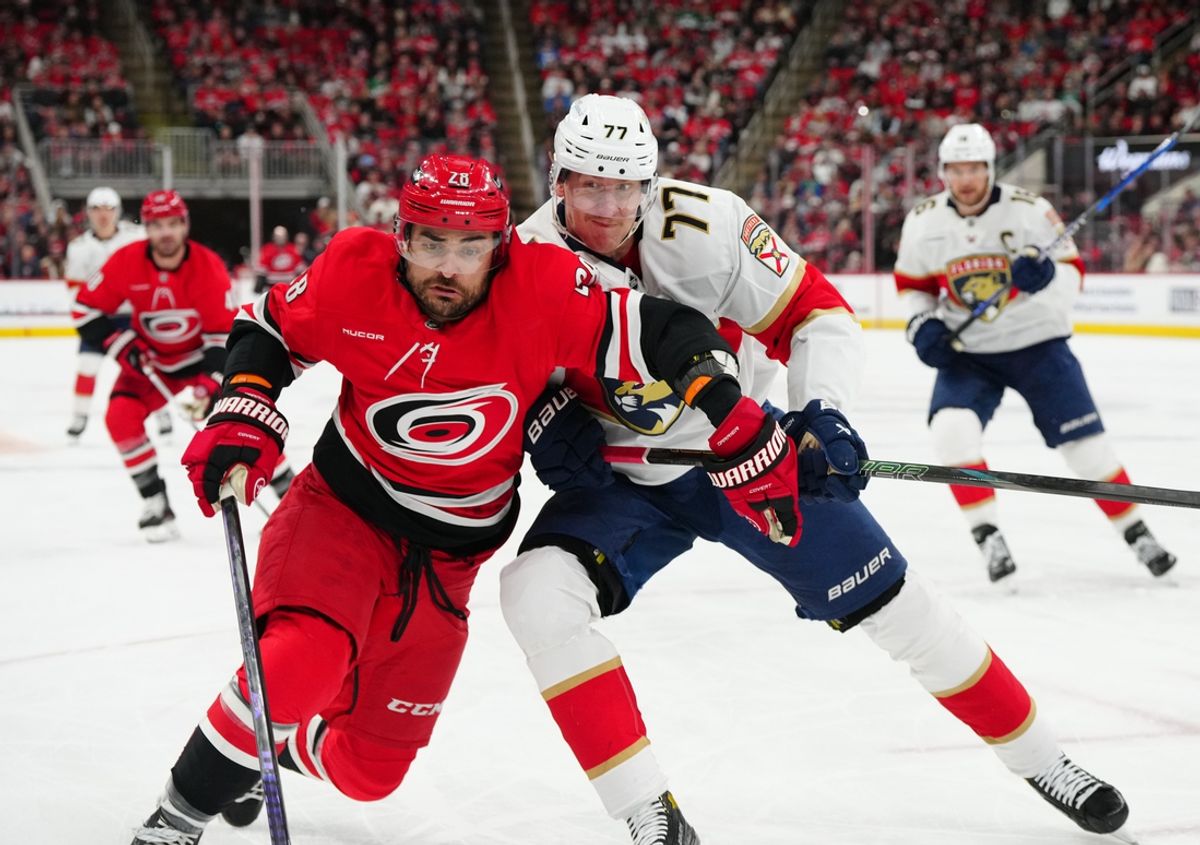Nov 29, 2024; Raleigh, North Carolina, USA;  Carolina Hurricanes left wing William Carrier (28) battles against Florida Panthers defenseman Niko Mikkola (77) during the first period at Lenovo Center. Mandatory Credit: James Guillory-Imagn Images
