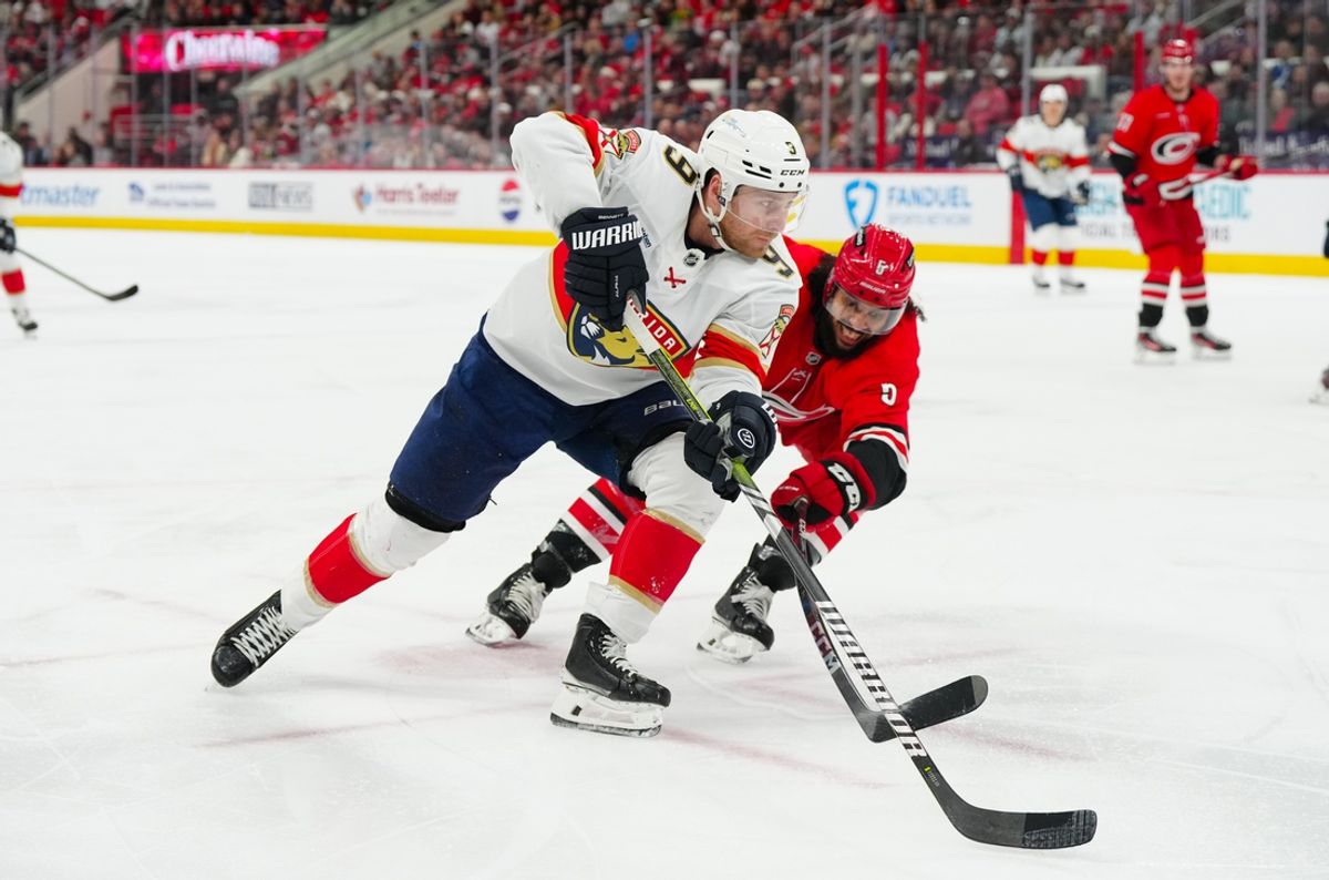 Nov 29, 2024; Raleigh, North Carolina, USA; Florida Panthers center Sam Bennett (9) takes the puck to thew outside of Carolina Hurricanes defenseman Jalen Chatfield (5) during the second period at Lenovo Center. Mandatory Credit: James Guillory-Imagn Images