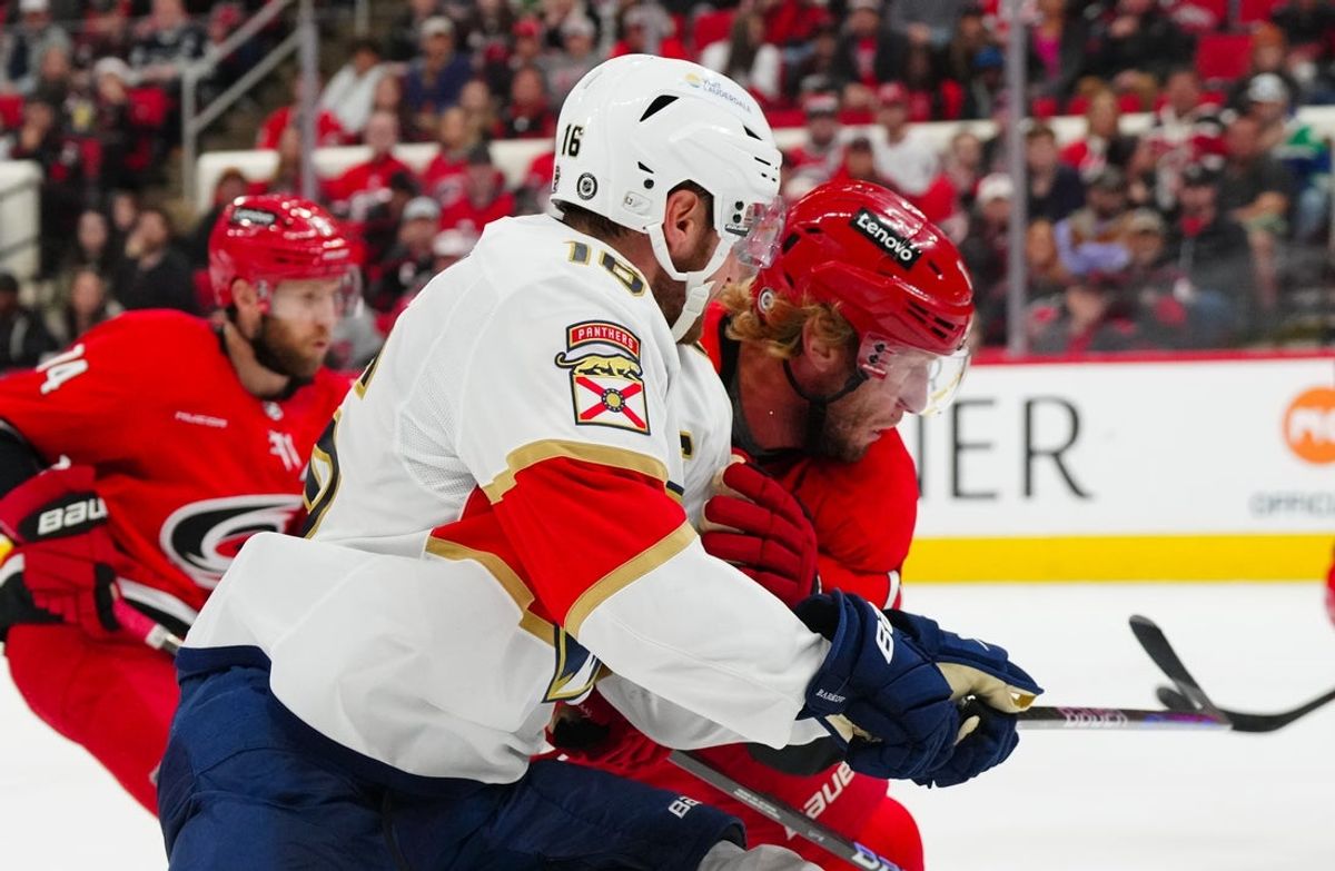 Nov 29, 2024; Raleigh, North Carolina, USA;  Carolina Hurricanes center Jordan Staal (11) checks Florida Panthers center Aleksander Barkov (16) during the second period t Lenovo Center. Mandatory Credit: James Guillory-Imagn Images