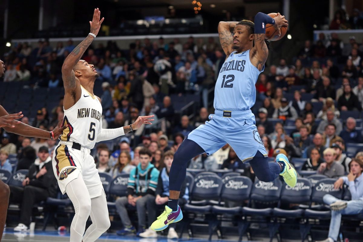 Nov 29, 2024; Memphis, Tennessee, USA; Memphis Grizzlies guard Ja Morant (12) passes the ball as New Orleans Pelicans guard Dejounte Murray (5) defends during the first quarter at FedExForum. Mandatory Credit: Petre Thomas-Imagn Images