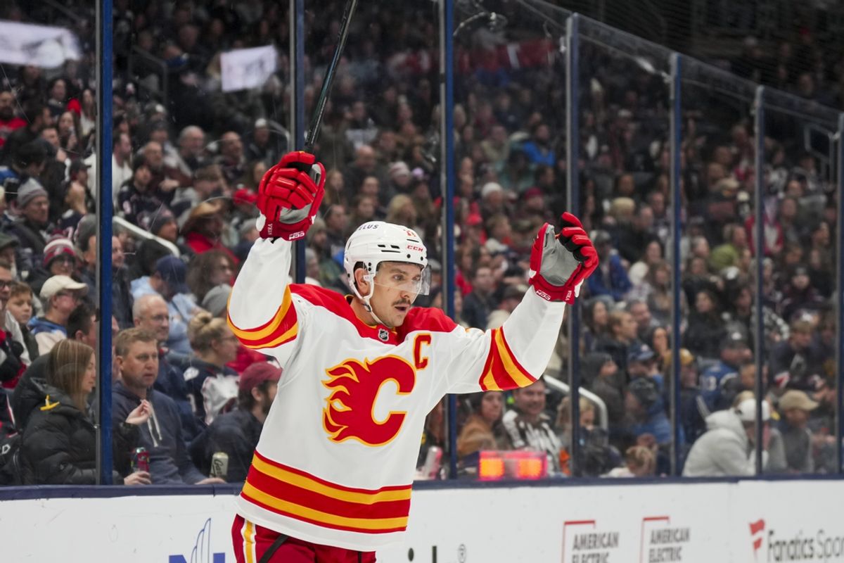 Nov 29, 2024; Columbus, Ohio, USA;  Calgary Flames center Mikael Backlund (11) celebrates the goal scored by center Nazem Kadri (91) in the game against the Columbus Blue Jackets in the third period at Nationwide Arena. Mandatory Credit: Aaron Doster-Imagn Images