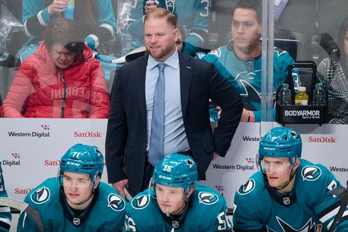 Nov 29, 2024; San Jose, California, USA; San Jose Sharks head coach Ryan Warsofsky, center Macklin Celebrini (71), right wing Ethan Cardwell (56) and center Nico Sturm (7) watch the play against the Seattle Kraken during the third period at SAP Center at San Jose. Mandatory Credit: Robert Edwards-Imagn Images
