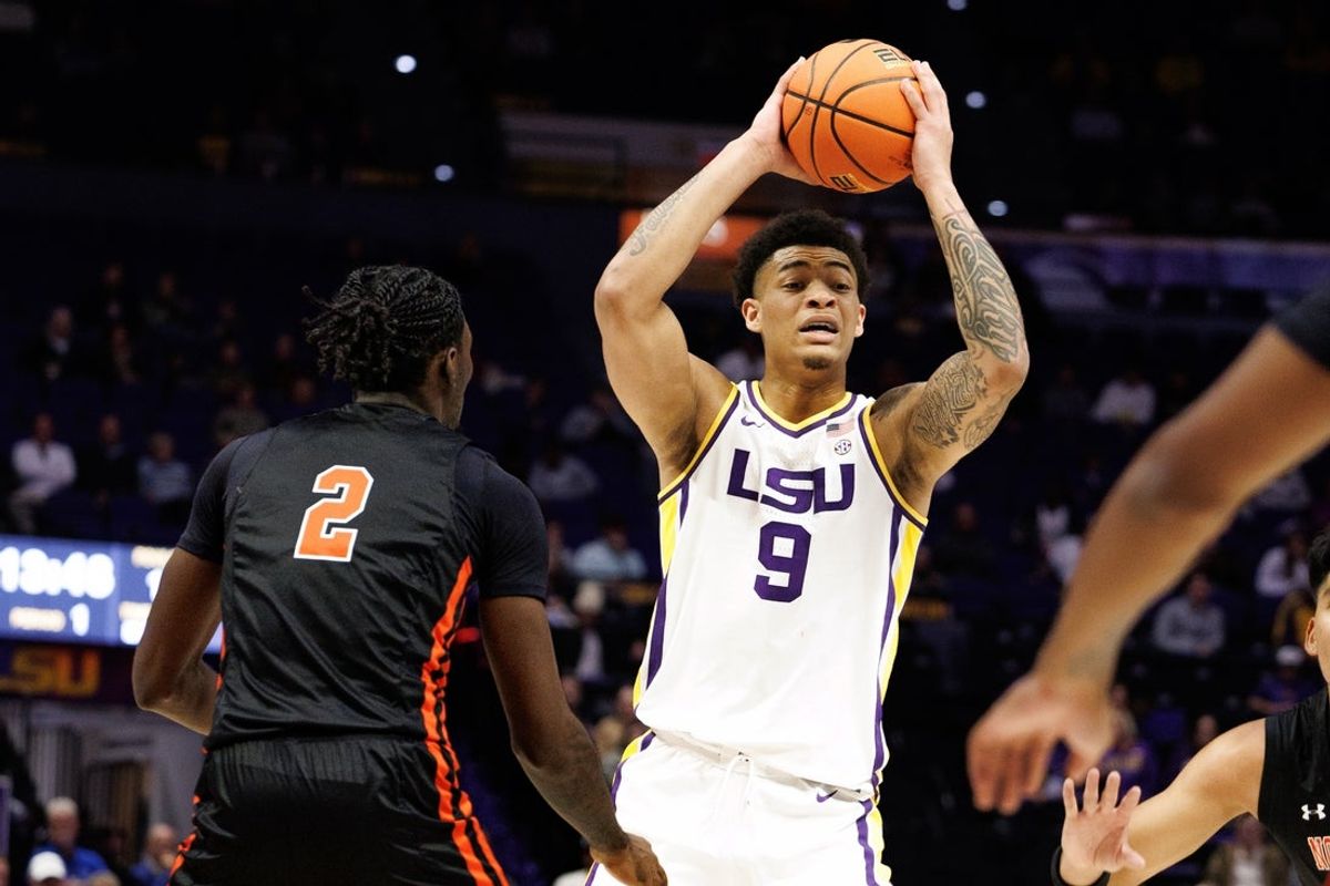 Nov 29, 2024; Baton Rouge, Louisiana, USA;  LSU Tigers forward Jalen Reed (9) looks to pass the ball against Northwestern State Demons forward Jerald Colonel (2) during the first half at Pete Maravich Assembly Center. Mandatory Credit: Stephen Lew-Imagn Images