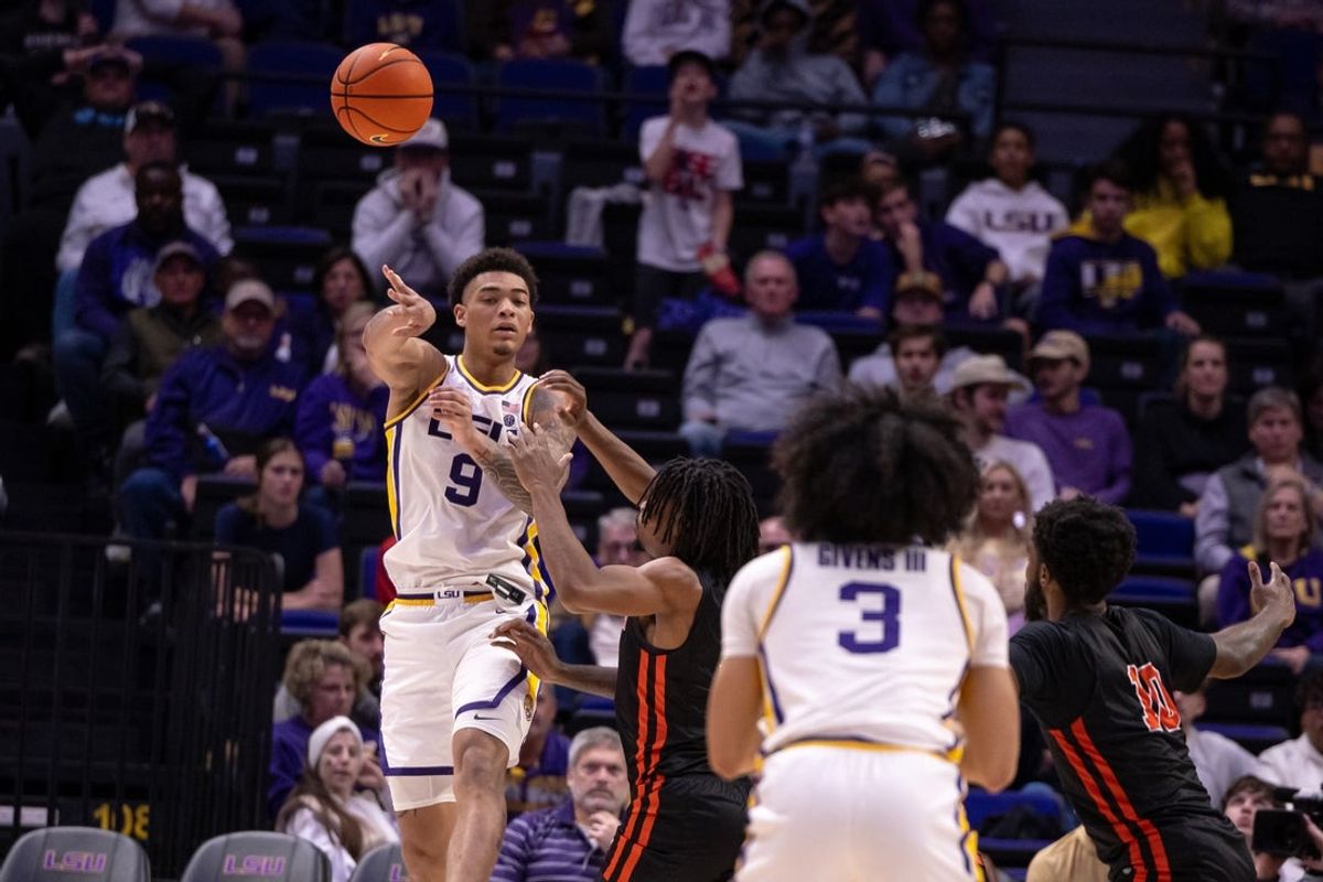 Nov 29, 2024; Baton Rouge, Louisiana, USA;  LSU Tigers forward Jalen Reed (9) passes the ball to guard Curtis Givens III (3) past LSU Tigers forward Daimion Collins (10) during the second half at Pete Maravich Assembly Center. Mandatory Credit: Stephen Lew-Imagn Images