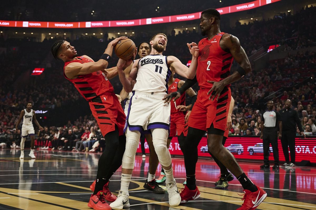 Nov 29, 2024; Portland, Oregon, USA; Sacramento Kings forward Domantas Sabonis (11) battles for control of a rebound during the first half against Portland Trail Blazers forward Toumani Camara (33) and center Deandre Ayton (2) at Moda Center. Mandatory Credit: Troy Wayrynen-Imagn Images
