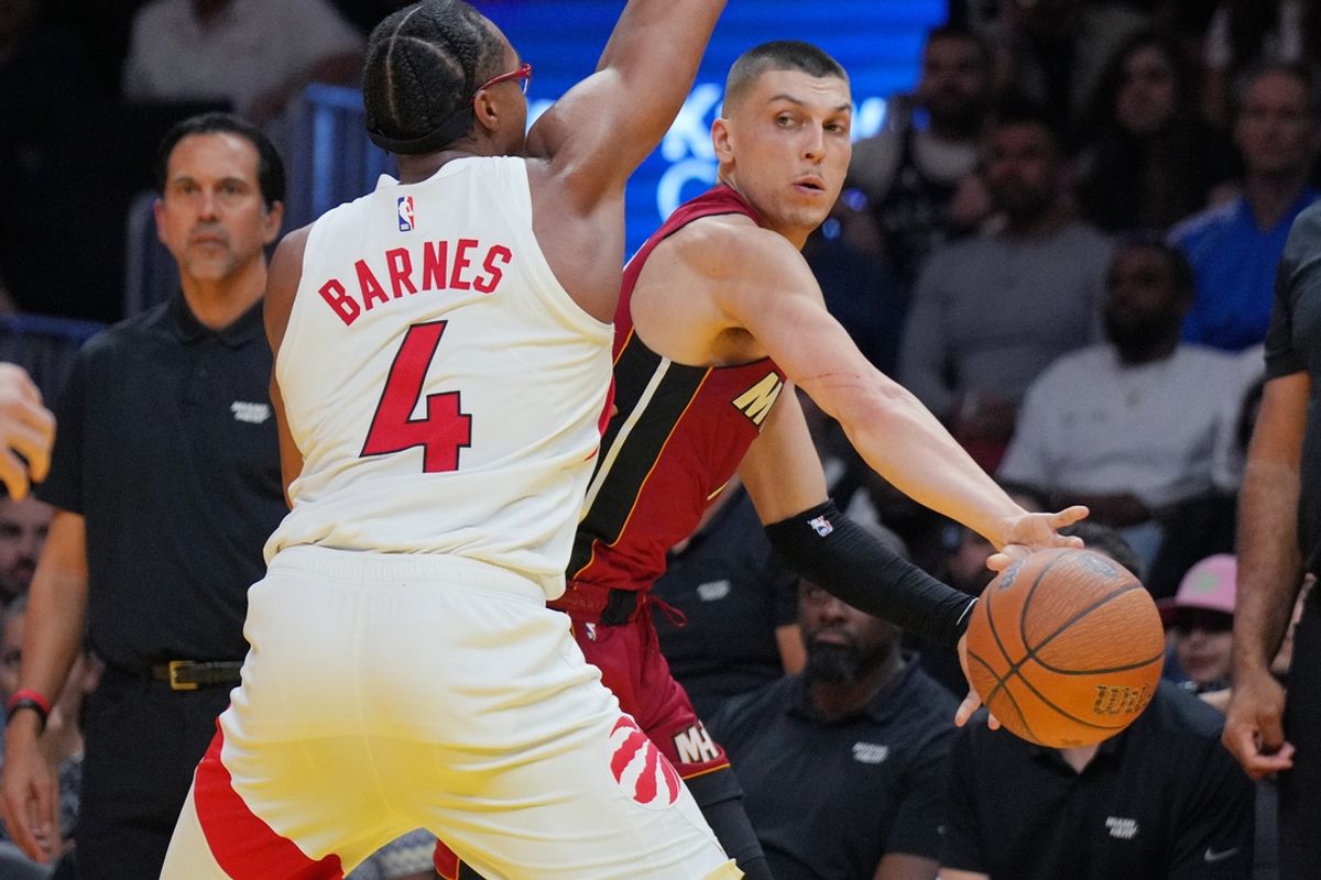 Nov 29, 2024; Miami, Florida, USA;  Miami Heat guard Tyler Herro (14) makes a pass around Toronto Raptors forward Scottie Barnes (4) during the second half in an NBA Cup game at Kaseya Center. Mandatory Credit: Jim Rassol-Imagn Images