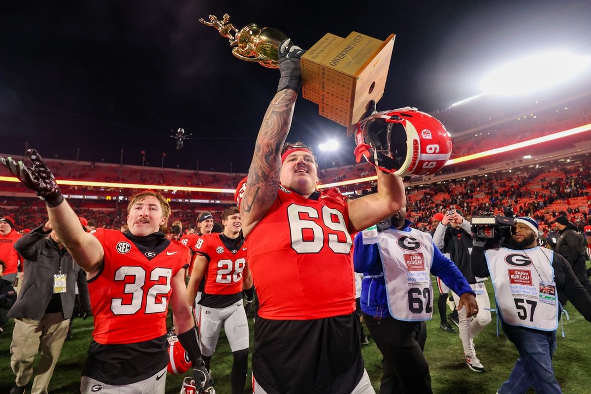 Nov 29, 2024; Athens, Georgia, USA; Georgia Bulldogs offensive lineman Tate Ratledge (69) holds the Governor’s Cup with running back Cash Jones (32) after a victory over the Georgia Tech Yellow Jackets in eight overtimes at Sanford Stadium. Mandatory Credit: Brett Davis-Imagn Images