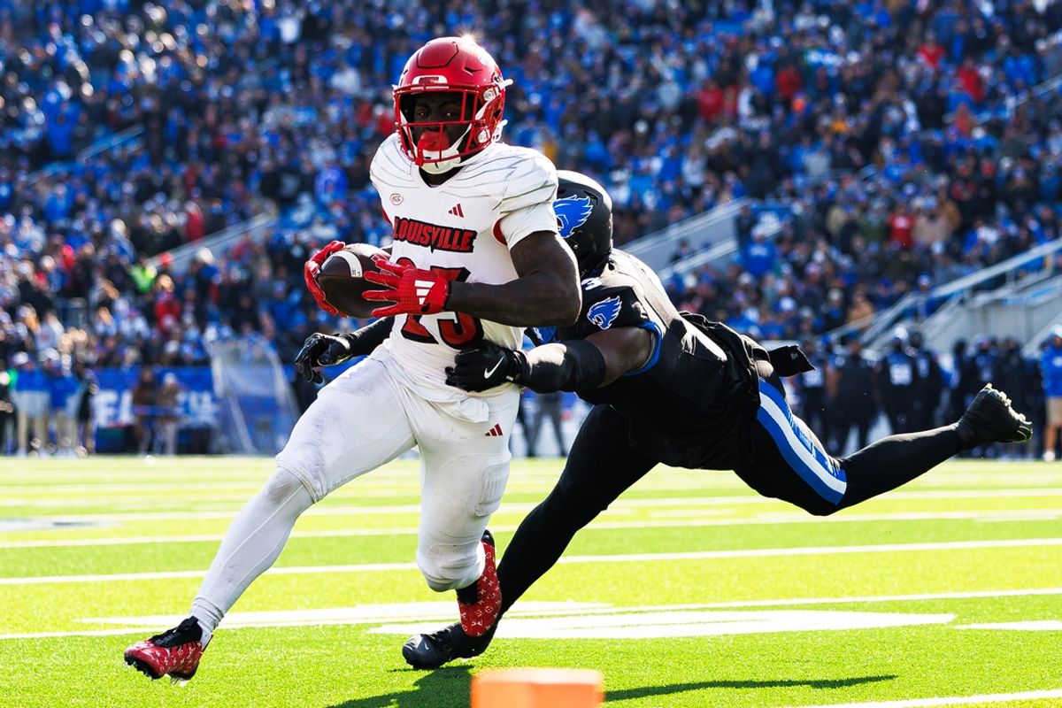Nov 30, 2024; Lexington, Kentucky, USA; Louisville Cardinals running back Isaac Brown (25) runs the ball against Kentucky Wildcats defensive back Alex Afari Jr. (3) during the first quarter at Kroger Field. Mandatory Credit: Jordan Prather-Imagn Images