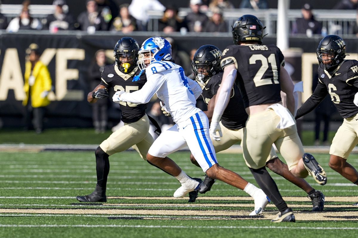 Nov 30, 2024; Winston-Salem, North Carolina, USA;  Duke Blue Devils wide receiver Jordan Moore (8) runs for yardage pursued by Wake Forest Demon Deacons defensive back Jamare Glasker (25) during the first half at Allegacy Federal Credit Union Stadium. Mandatory Credit: Jim Dedmon-Imagn Images
