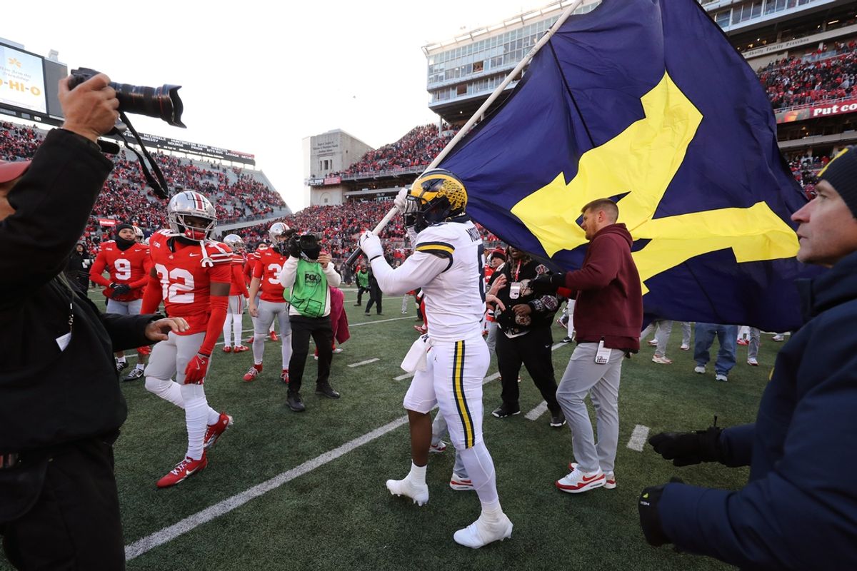 Nov 30, 2024; Columbus, Ohio, USA;  Michigan Wolverines defensive end Derrick Moore (8) attempts to plant the flag on the Ohio State Buckeyes logo as Ohio State Buckeyes defensive end Jack Sawyer (33) rips the flag down after the game at Ohio Stadium. Mandatory Credit: Joseph Maiorana-Imagn Images