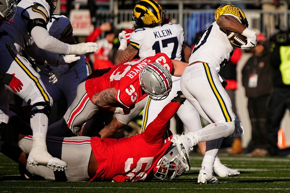 Michigan Wolverines running back Kalel Mullings (20) runs past Ohio State Buckeyes defensive tackle Ty Hamilton (58) during the second half of the NCAA football game at Ohio Stadium in Columbus on Saturday, Nov. 30, 2024. Michigan won 13-10.