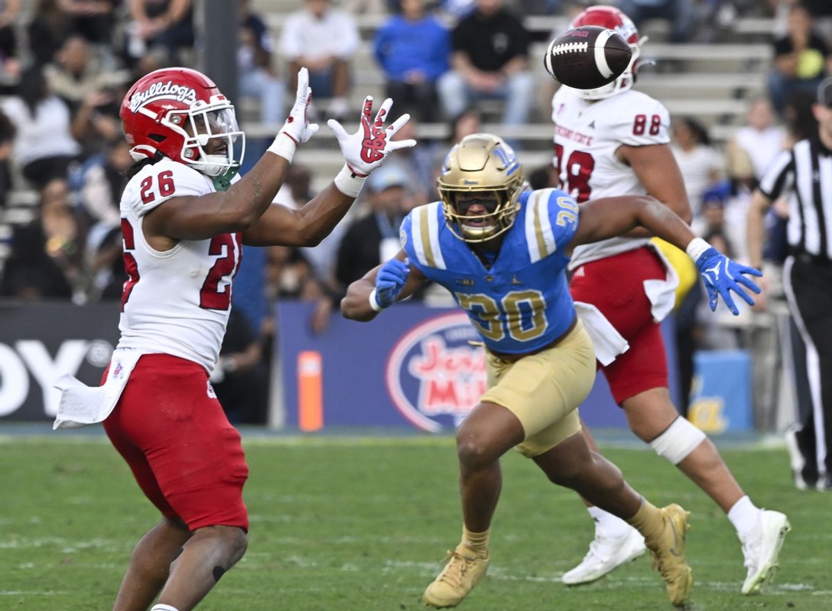Nov 30, 2024; Pasadena, California, USA; Fresno State Bulldogs running back Bryson Donelson (26) catches a pass as UCLA Bruins linebacker Joseph Vaughn (30) moves in during the second quarter during the second quarter at Rose Bowl. Mandatory Credit: Robert Hanashiro-Imagn Images