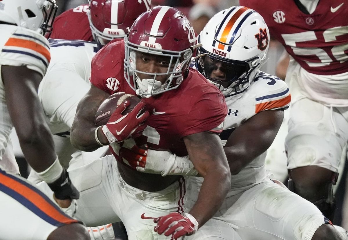 Nov 30, 2024; Tuscaloosa, Alabama, USA;  Alabama Crimson Tide running back Jam Miller (26) is tackled by Auburn Tigers buck Jalen McLeod (35) during the second half at Bryant-Denny Stadium. Alabama won 28-14. Mandatory Credit: Gary Cosby Jr.-Imagn Images