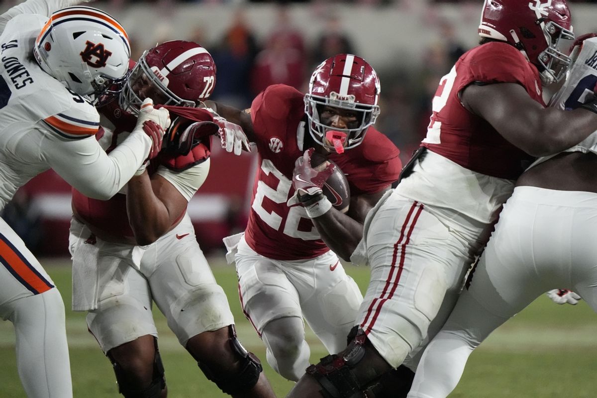 Nov 30, 2024; Tuscaloosa, Alabama, USA;  Alabama Crimson Tide running back Justice Haynes (22) runs behind offensive lineman Parker Brailsford (72) and offensive lineman Tyler Booker (52) against the Auburn Tigers during the second half at Bryant-Denny Stadium. Alabama won 28-14. Mandatory Credit: Gary Cosby Jr.-Imagn Images